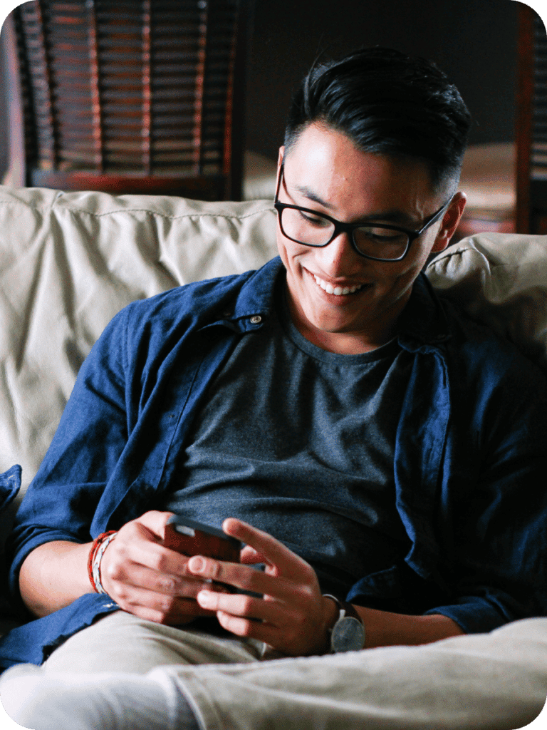 man smiling while shopping on mobile for auto refinance loan