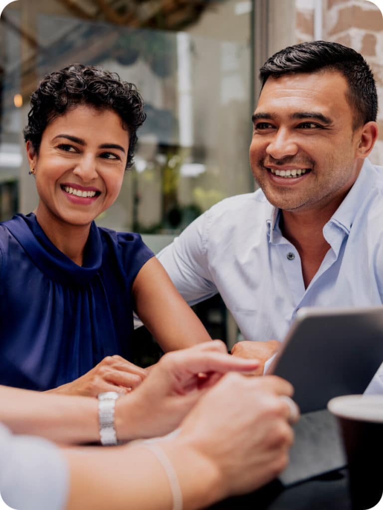 Couple smiling a third person is out of view