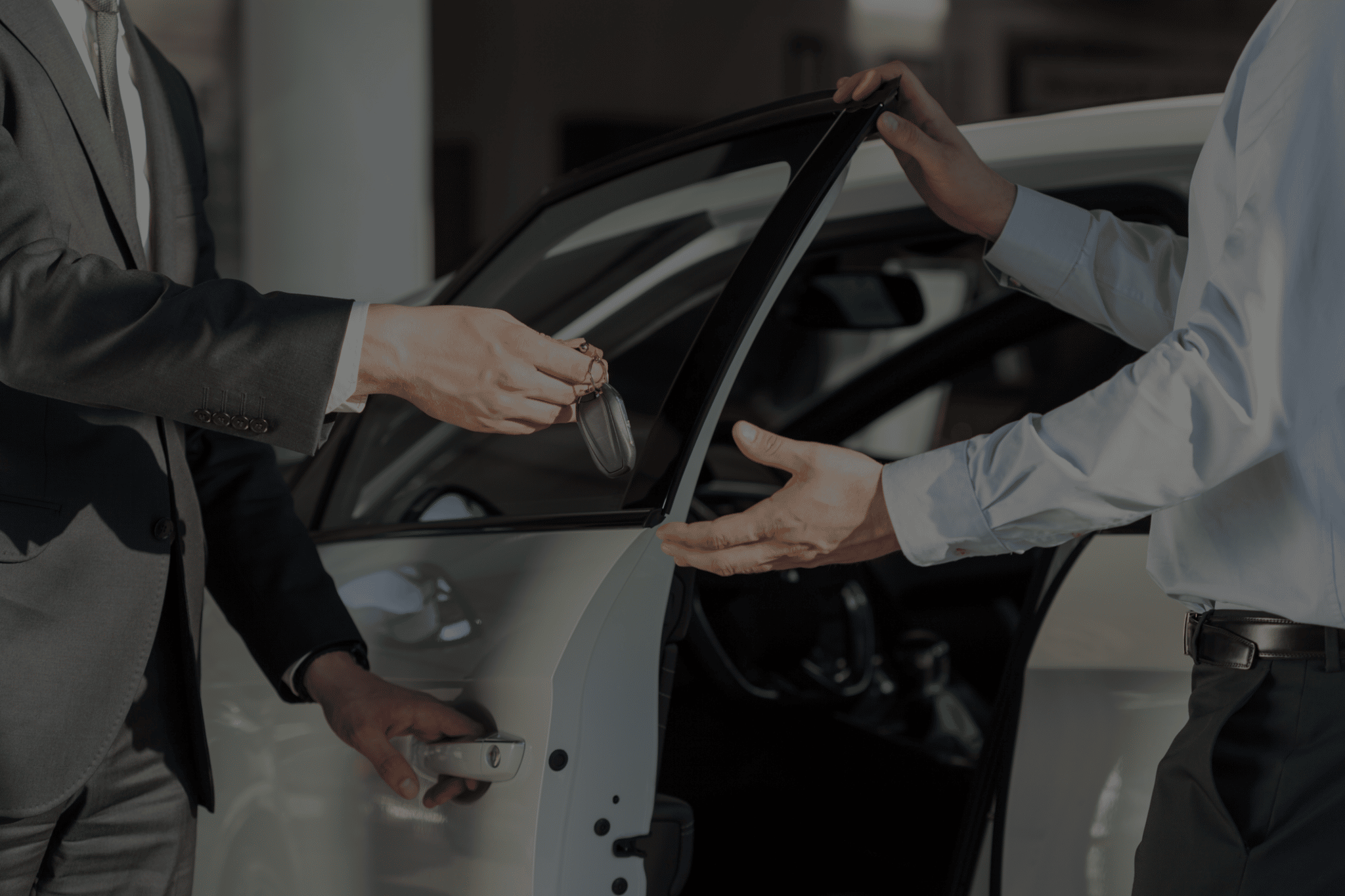 hands exchanging keys after new auto loan vehicle purchase
