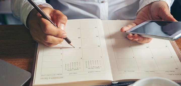 Man using calendar and calculator