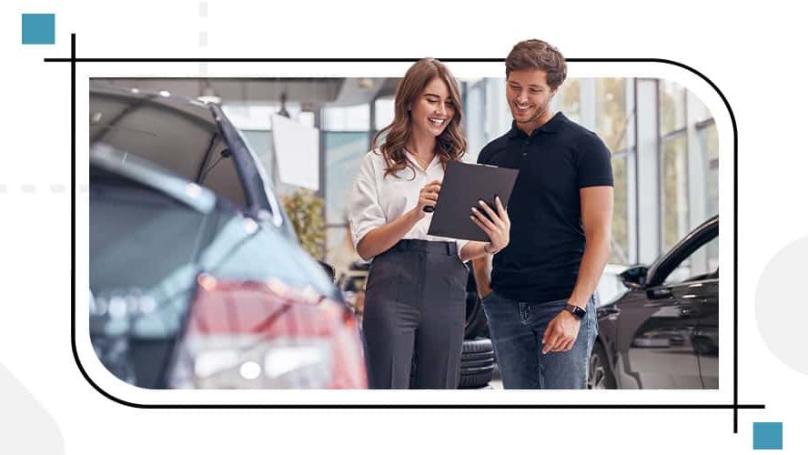 Two individuals standing next to a car, reviewing documents