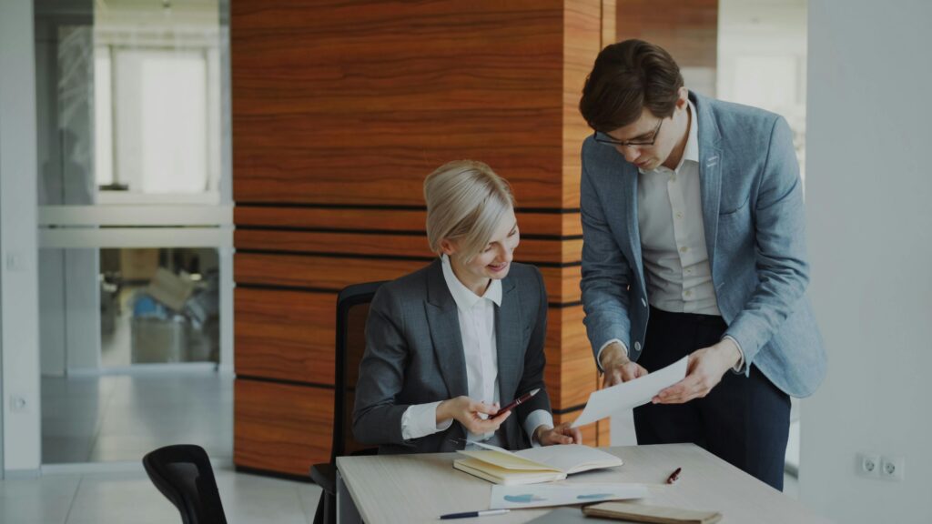 Two people going over paperwork in an office.