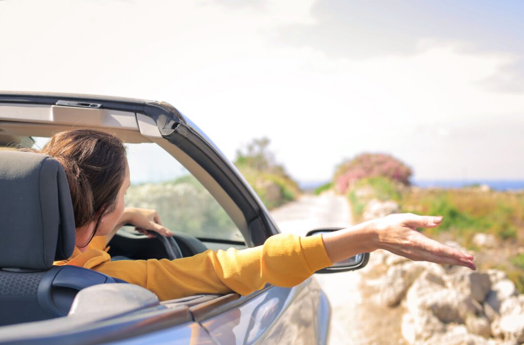 Women driving a convertible car.