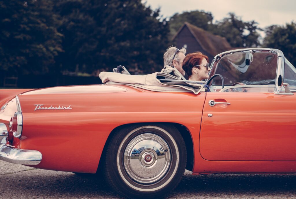 Couple driving in thunderbird car