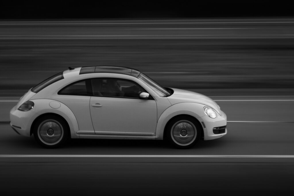 VW bug car driving in black and white photo