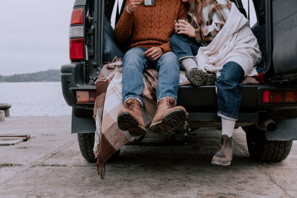 People sitting in truck of car wearing fall clothes
