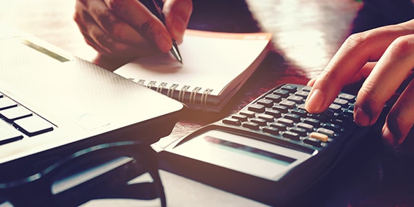 person using a calculator and notepad