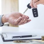 Person handing over keys to a car