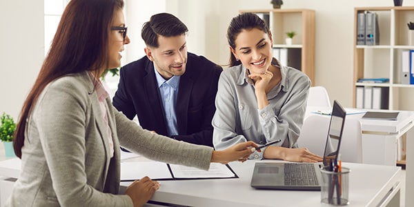 Professional woman showing a couple something on a laptop