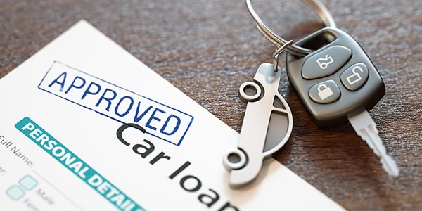 car keys on top of an approved car loan letter