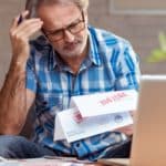 Man looking down at bills marked past due