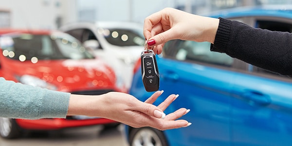 Woman handing car keys to another woman