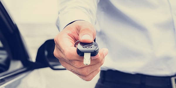 man handing car key away