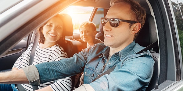 family smiling while driving in a car